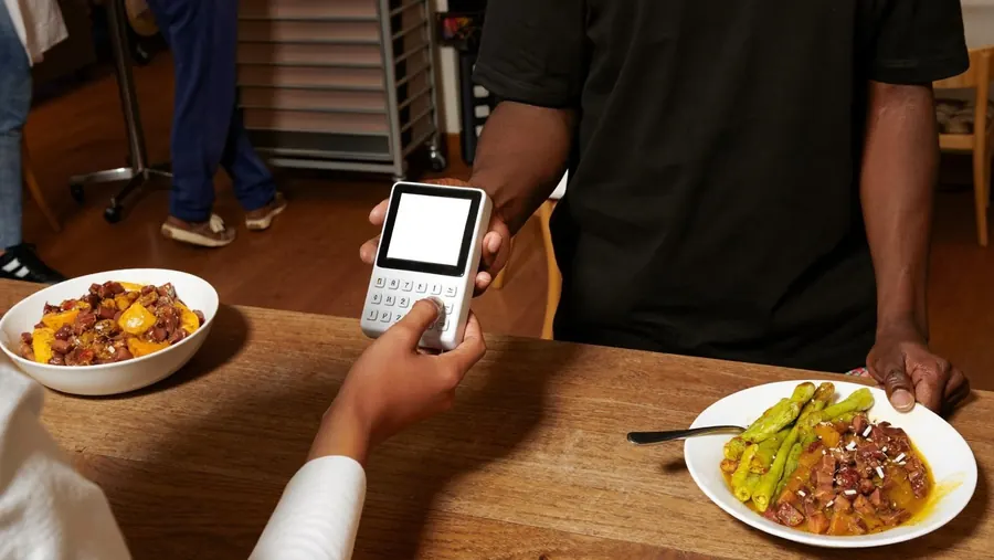 A customer paying on a Sao POS terminal at a restaurant table